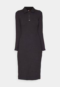 Robe midi noire à manches longues avec col et zipper frontal, silhouette ajustée, petit logo horizontal sous la fermeture éclair.