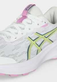 Λευκό αθλητικό παπούτσι Asics με ροζ λεπτομέρειες, κίτρινες και σκουροπράσινες ρίγες λογότυπου και λευκά κορδόνια σε φωτεινό φόντο.