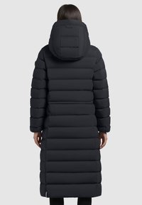 Giacca a vento nera lunga con cappuccio, caratterizzata da un design trapuntato, cuciture visibili e una silhouette slanciata. Nessun hardware o accenti in evidenza.