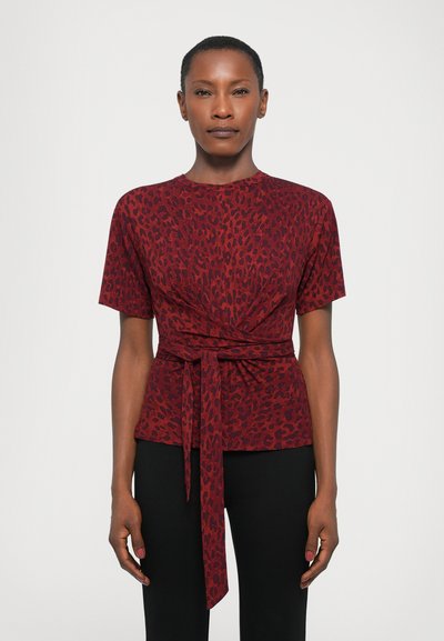 Red short-sleeve top with a leopard print, featuring a knotted detail at the waist for a fitted silhouette. Smooth, lightweight fabric.