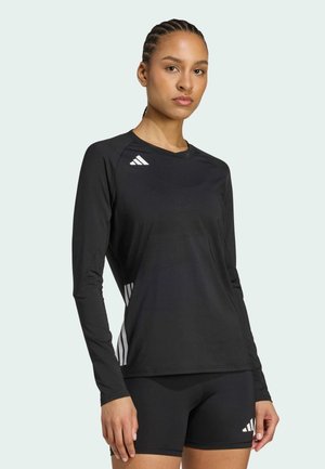 Maglietta sportiva nera a maniche lunghe con colletto rotondo, con accenti a tre strisce bianche sulle maniche e sul lato. Materiale liscio e elasticizzato.