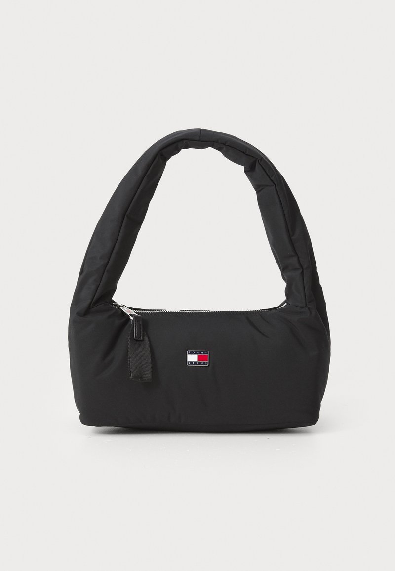 Schwarze Nylon-Handtasche mit einem gebogenen, gepolsterten Griff, silbernem Reißverschluss und einem kleinen Logo-Patch in Rot, Weiß und Blau.