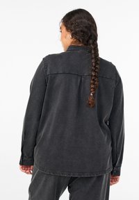 Dunkelgraues Denimhemd mit langen Ärmeln, geknöpften Manschetten, Rückenfalte und klassischem Kragen; verfügt über eine lockere Passform.