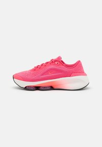Nike löparskor i stark rosa med texturerad mesh-översida, vadderad krage och vit syntetisk sula. Har luftdämpning och svart yttersula.