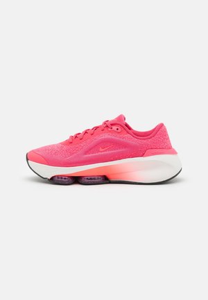 Nike löparskor i stark rosa med texturerad mesh-översida, vadderad krage och vit syntetisk sula. Har luftdämpning och svart yttersula.