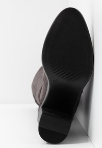 Bottine en daim marron avec une semelle en caoutchouc noire. Caractérisée par un design à bout carré et une surface texturée. Taille indiquée : 37.