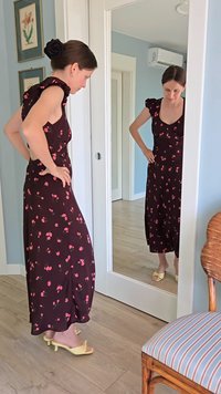 Brown, floral maxi dress with ruffled sleeves, featuring pink flower patterns; paired with yellow heeled sandals. Full-length mirror reflection.