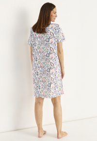 Kortärmad nattskjorta i lätt tyg med ett flerfärgat blommigt paisleymönster, vågig nederkant och avslappnad passform.