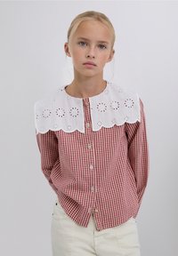 Red and white gingham shirt with a white eyelet lace collar, featuring a button front and long sleeves. Simple design and textured fabric.