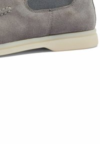 Deportiva gris de ante con un panel de tejido texturizado, detalles de cordones y suela de goma. Presenta un acabado suave y un área de tobillo acolchada.