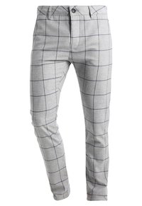 Szare spodnie w kratę wykonane z lekkiego materiału, o dopasowanym kroju, z przodem zapinanym na guzik, bez tylnych kieszeni. Kontrastujący granatowy wzór w kratkę.