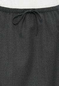 Sötétszürke elasztikus derékpántos nadrág, illeszkedő húzózsinórral. Az anyag finom textúrával rendelkezik, könnyű és sima megjelenésű.