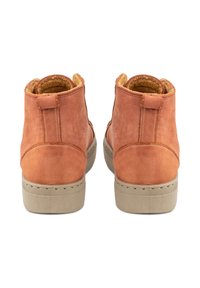 Botas de ante marrón hasta el tobillo con un forro suave, que presentan una suela de goma beige texturizada y una pequeña lengüeta en la parte trasera para facilitar su puesta.