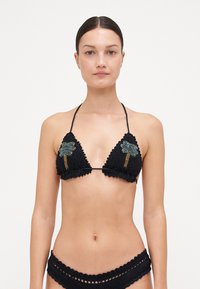 Bikini nero in crochet con coppe triangolari, impreziosito da decorazioni a forma di palma verde, bordi ondulati e lacci regolabili al collo e sulla schiena.