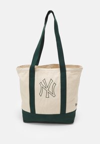 Sac tote en coton avec des anses et une base vertes, corps crème, présentant un logo NY brodé sur le devant. Design robuste et spacieux.