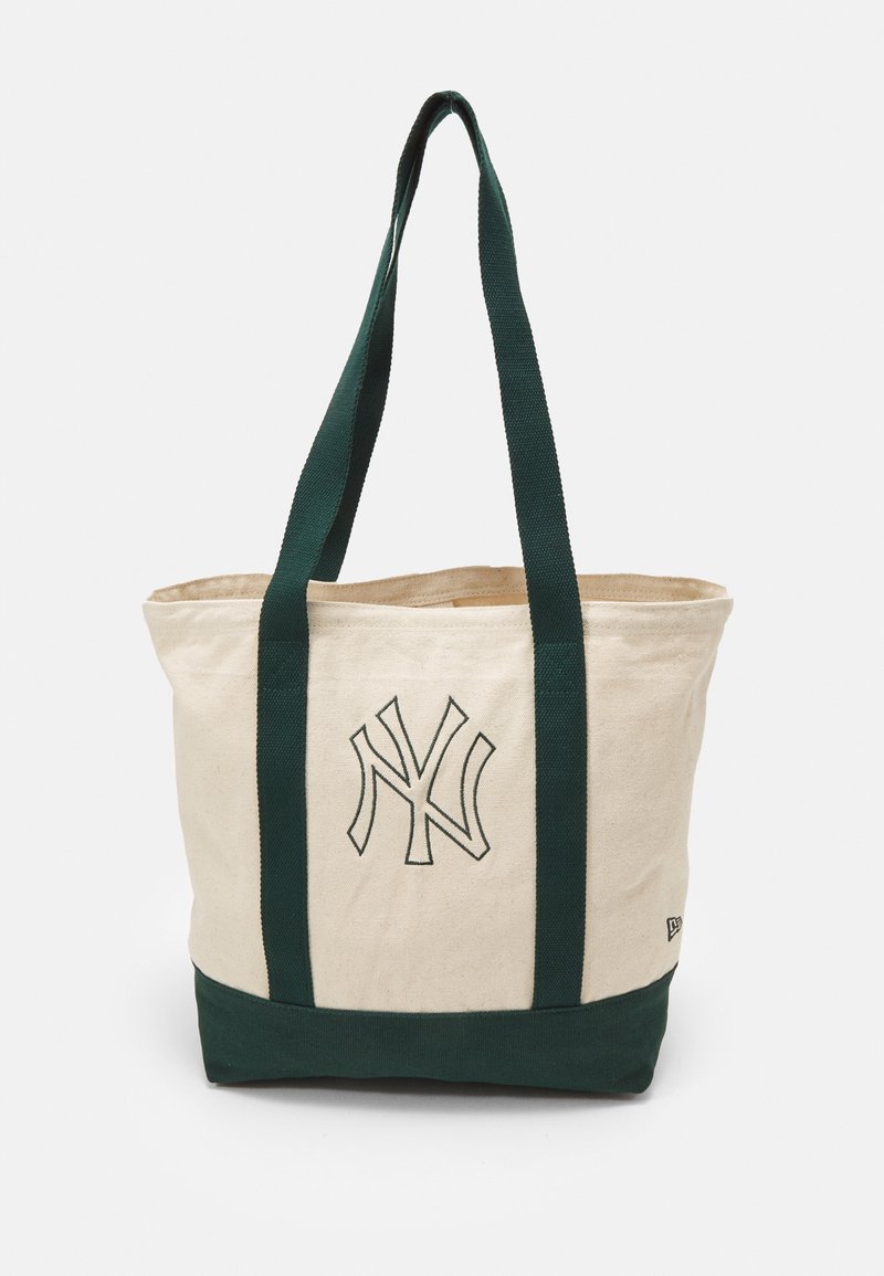 Sac tote en coton avec des anses et une base vertes, corps crème, présentant un logo NY brodé sur le devant. Design robuste et spacieux.