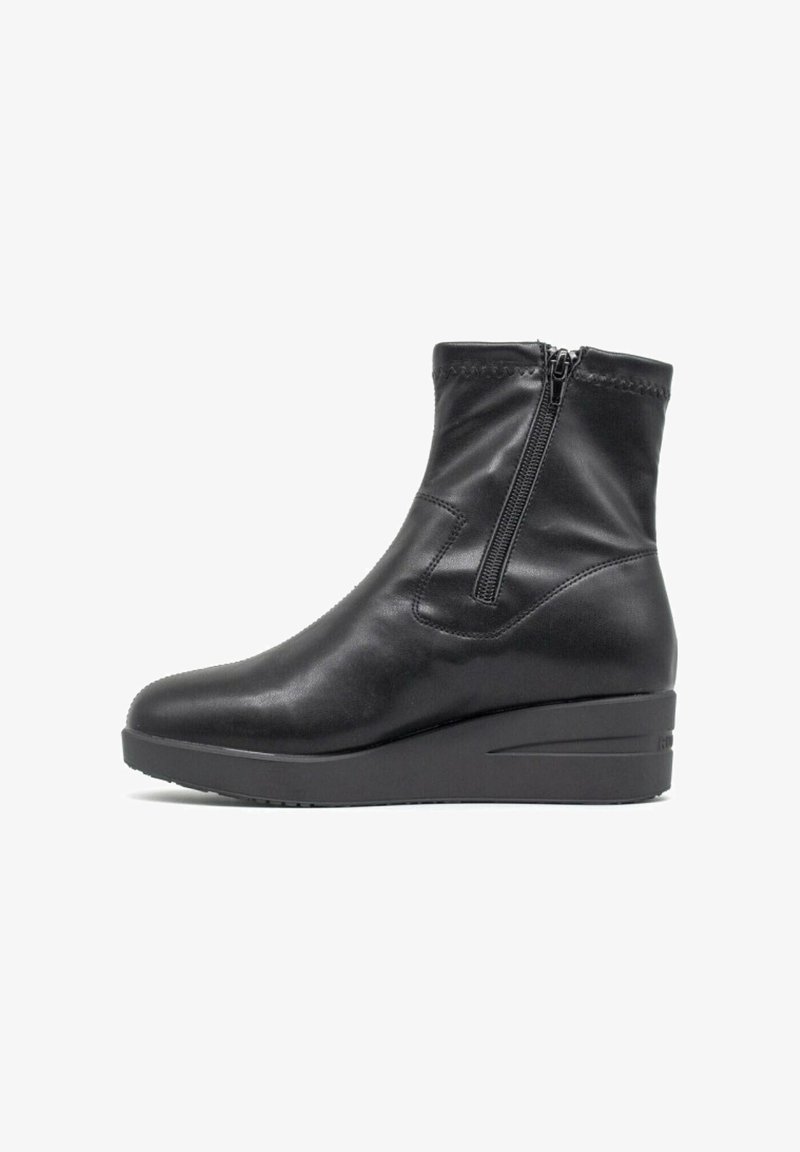 Stivali ankle in pelle nera con cerniera laterale, texture liscia, tacco a wedge e dettagli di cucitura attorno al collo.