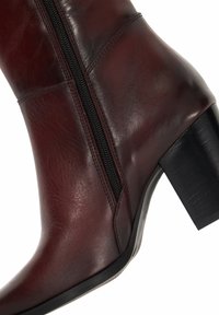 Burgundy leather ankle boot with a side zipper, a rounded toe, and a block heel. Features smooth texture and subtle stitching details.