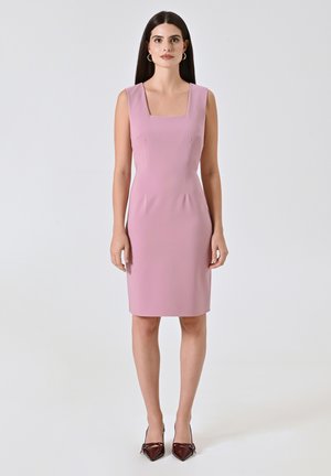 Roze getailleerde jurk met een vierkante halslijn, mouwloos ontwerp en een gladde textuur. Draag met puntige bruine hakken, op een lichte achtergrond.