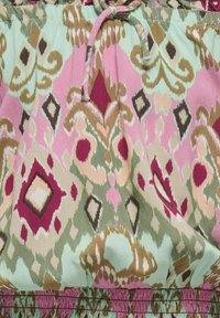 Un tessuto multicolore presenta intricate spirali e motivi a diamante. I colori includono rosa, verde menta, marrone e rosso, con una finitura texture.