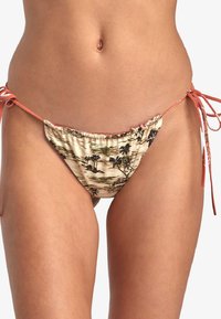 Bas de bikini en beige clair avec un motif de palmier et de plage. Doté de lien coral ajustable sur les côtés et d'une texture douce froncée.