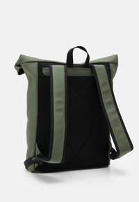 Rullesekk i olivengrønn med mesh svart bakpanel, polstrede justerbare stropper og teksturerte detaljer, med quiltede elementer.