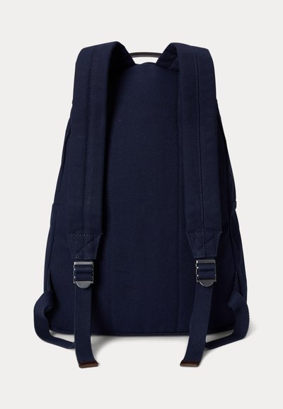 Rucsac bleumarin cu bretele căptușite reglabile, catarame metalice și un mâner din material textil în partea de sus, văzut din spate.