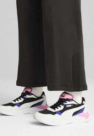 Black and white athletic shoes with pink and purple accents, featuring a mesh upper, padded collar, and textured sole.