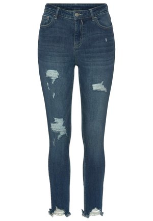 Tievās džinsos tumši zilā denima ar noberzumiem un saplēstiem malām. Iespējo klasisko piecu kabatu dizainu un metāla pogas aizvēršanu.