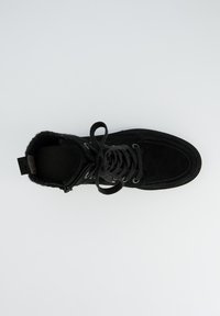 Botte chelsea en daim noir avec bout rond, cordon de serrage à l'avant, doublure intérieure et languette au niveau du talon. Présente une surface texturée et des œillets en métal pour les lacets.