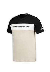 Maglietta a maniche corte nera e beige con una grande striscia bianca sul petto, con il testo e il logo "LECOQSPORTIF" sulla manica.