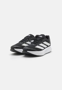 Black running shoes with mesh upper, white three-stripe logo, padded collar, black laces, and textured rubber sole for grip.