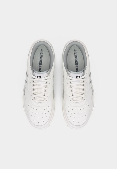 Ζευγάρι λευκά χαμηλά αθλητικά παπούτσια με διάτρητη μύτη, λευκά κορδόνια και γκρι εσωτερική επένδυση, σε θέα από ψηλά.