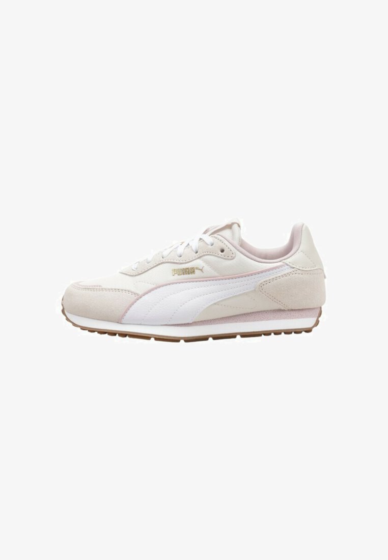 Zapatilla baja beige y blanca de Puma con acentos de ante, suela de goma y logotipo dorado de Puma en el lateral.