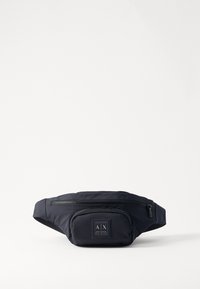 Fanny pack en nylon navy avec bandoulière réglable, poche zippée à l'avant et patch logo. Design compact avec texture lisse et matériel durable.