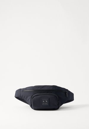 Bumbag de nylon navy con correa ajustable, bolsillo frontal con cremallera y parche con logo. Diseño compacto con textura suave y hardware duradero.