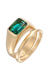 Guldfarvet ring med en stor smaragdskåret grøn sten, sammen med en glat, slank ring. 925 sølvstempel synligt på indersiden.