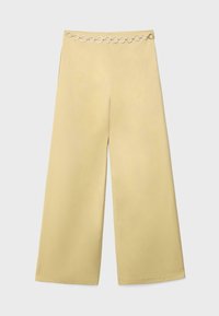 Béžové široké kalhoty s vysokým pasem a stříbrným řetízkovým páskem s kruhovými články kolem pasu.