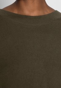 Maglione a coste verde oliva con scollatura ampia e arrotondata e finitura testurizzata, che mette in mostra il motivo del knit sul retro.