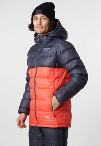 Padded-Jacke mit navyblauem oberen und leuchtend rotem unteren Abschnitt. Enthält eine Kapuze, Stehkragen und Reißverschlusstaschen. Hergestellt aus glattem Material.