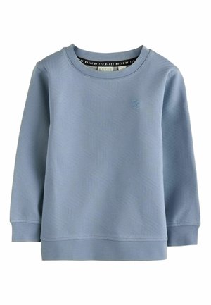 Sweatshirt bleu à col rond en tissu texturé, avec un motif géométrique subtil et un petit logo "TB" sur le devant.