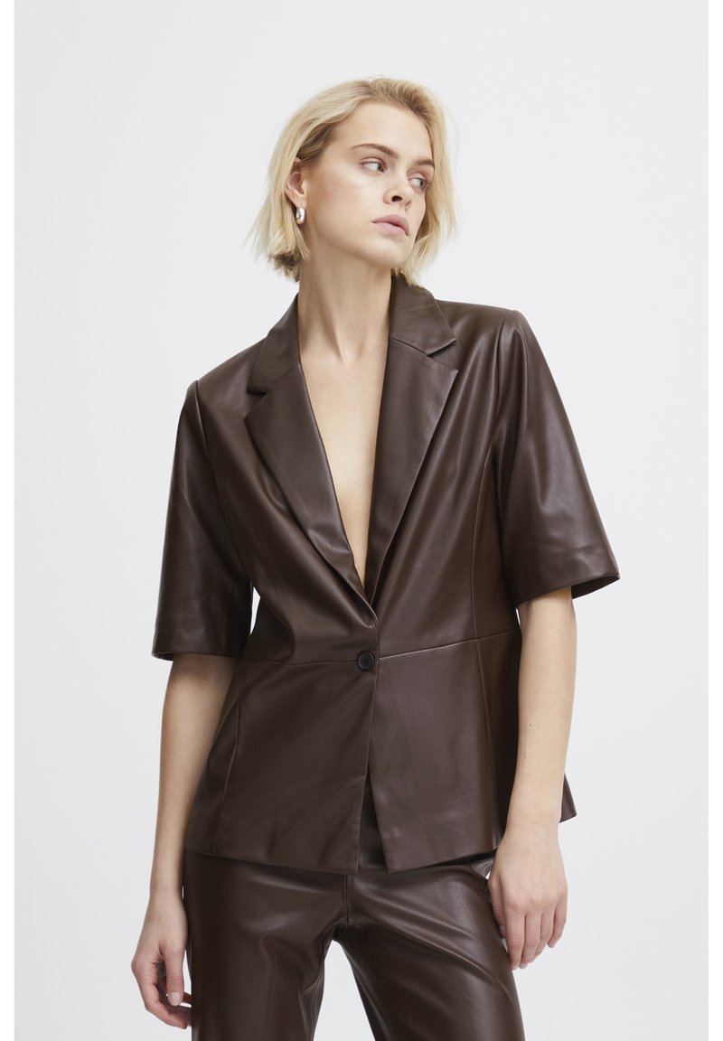 Blazer en cuir marron avec un décolleté en V profond, des manches courtes et une fermeture à un seul bouton. Texture lisse et coupe ajustée.