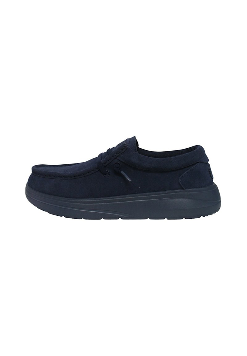 Zapato de ante azul marino tipo zueco con punta redonda, suela de goma flexible y cordones decorativos. Presenta detalles de costura mínimos.