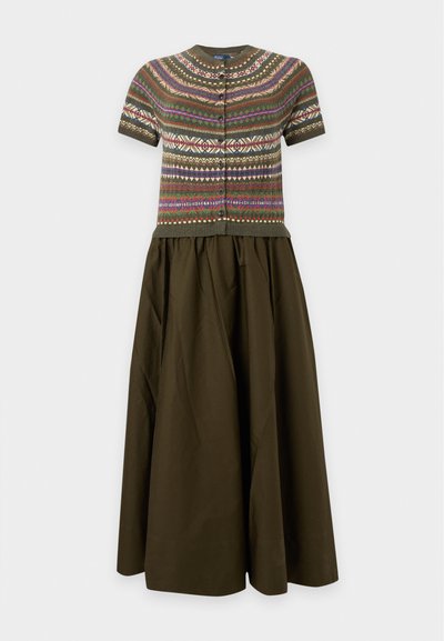 Cardigan en maille à manches courtes avec des motifs géométriques multicolores, associé à une jupe longue taille haute couleur olive.