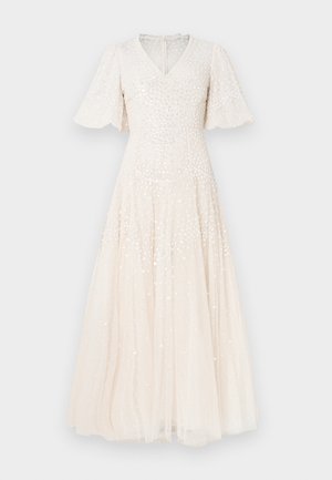 Φόρεμα σε ανοιχτό μπεζ χρώμα μήκους μέχρι τον αστράγαλο, με V-λαιμόκοψη, κοντά μανίκια τύπου φλάτερ και διακοσμημένο με παγιέτες. Το μαλακό τούλι προσθέτει μια υφή στρώματος.