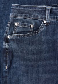 Jeans de denim azul oscuro con un bolsillo frontal con remaches metálicos, costuras sutiles y una textura suave. Cintura alta con un corte clásico.