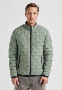 Hellgrüne Steppjacke mit Stehkragen, Frontreißverschluss und zwei Seitentaschen. Gepolstertes Design und schwarze Akzente an Bündchen und Saum.