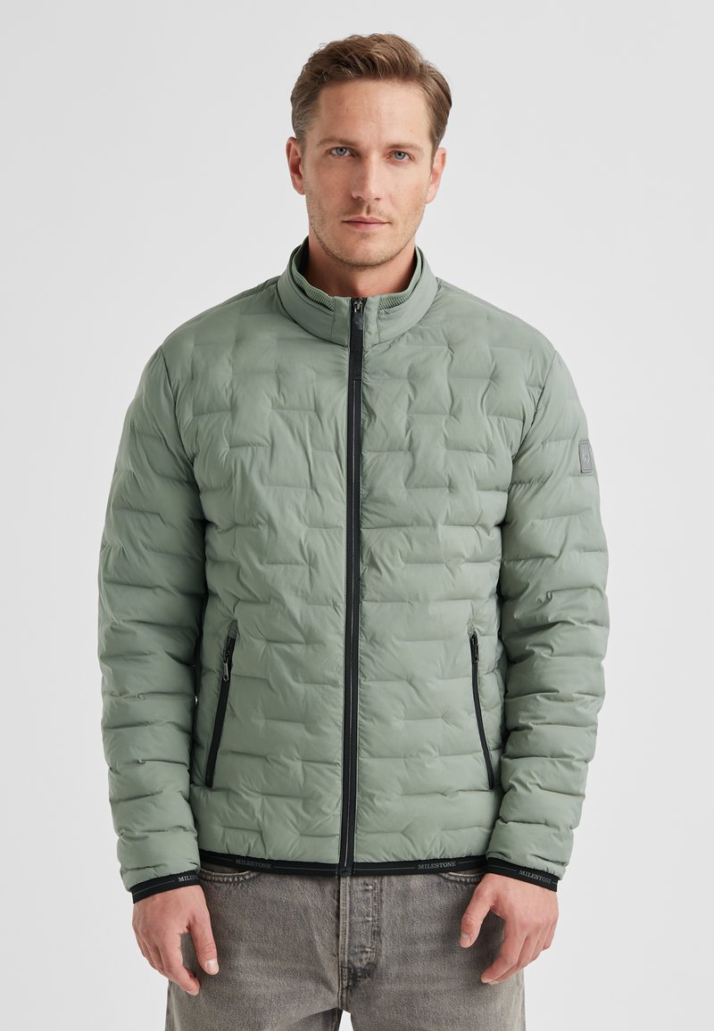 Hellgrüne Steppjacke mit Stehkragen, Frontreißverschluss und zwei Seitentaschen. Gepolstertes Design und schwarze Akzente an Bündchen und Saum.