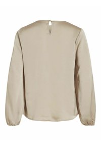 Beige blouse met lange mouwen van een gladde stof, ronde halslijn en een sleutelgatdetail aan de achterkant. Heeft gathers aan de manchetten van de mouwen.