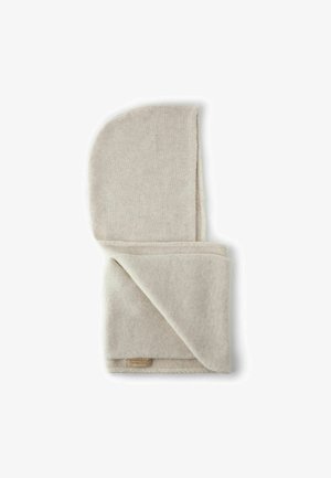 Hellbeige gestrickte Decke mit weicher Textur, gefaltet mit einer abgerundeten Ecke. Verfügt über ein Etikett mit Markennamen, saubere Verarbeitung an den Rändern.